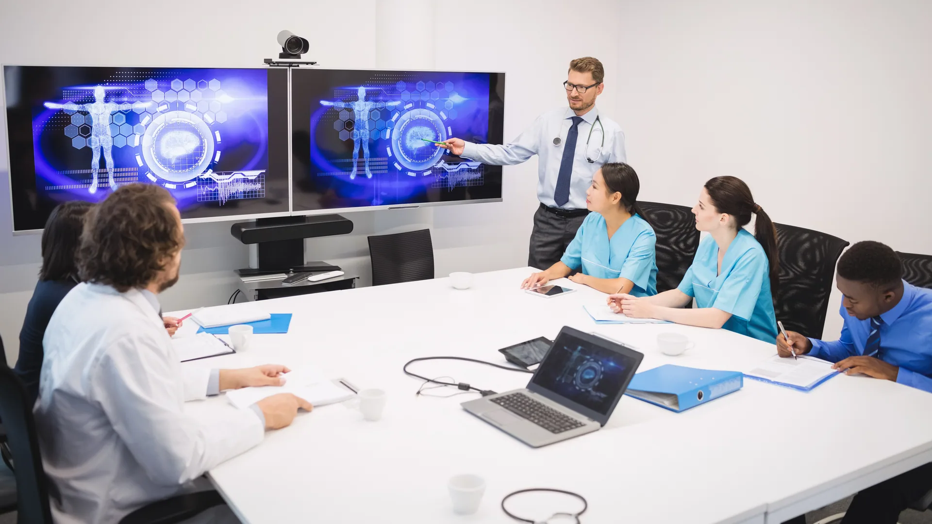 A clinical team reviewing medical imaging together in a meeting room.